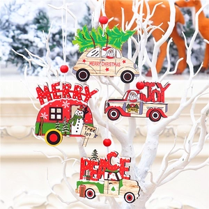 Détail de quatre suspensions de Noël en bois coloré en forme de voiture sur branche blanche