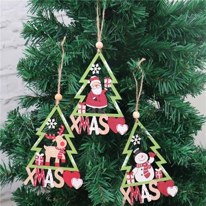 Three-piece set of wooden Santa and snowman ornaments hanging on a Christmas tree