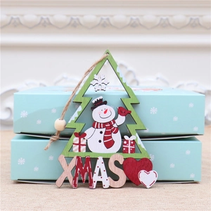 Detail of wooden Christmas tree ornament with snowman design and XMAS engraving