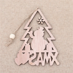 Detail of wooden Christmas tree ornament with snowman cutout and XMAS engraving on burlap