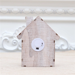 Detail of the back of wooden house ornament showing battery box and power switch