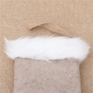 Gros plan d'une botte de Noël avec bordure peluche blanche et boucle en lin rustique