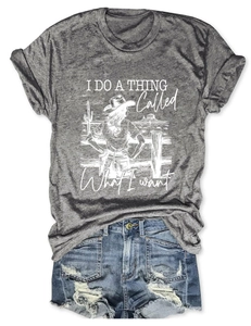 Flat lay of gray tee with vintage woman design and distressed blue denim shorts