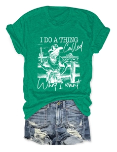 Detailed flat lay of a green vintage graphic tee with desert motif and denim shorts