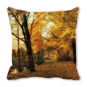 Detailed close-up of autumn forest landscape print on a soft peach skin cushion cover