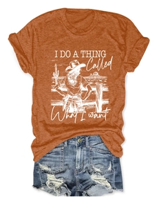 Flat lay of burnt orange T-shirt with 'What I Want' print and distressed denim shorts