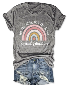 Détail à plat d'un t-shirt gris avec motif arc-en-ciel et short en jean usé