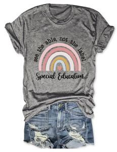 Détail à plat d'un T-shirt gris avec l'imprimé graphique 'See the able, not the label'