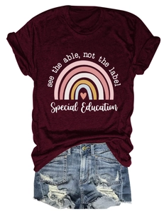 Détail du t-shirt bordeaux avec texte et short en jean effiloché en gros plan