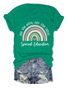 Détail d'un t-shirt vert à col rond avec motif arc-en-ciel et texte positif