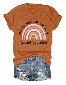 T-shirt orange brûlé à motif arc-en-ciel et short en jean posé à plat sur fond blanc