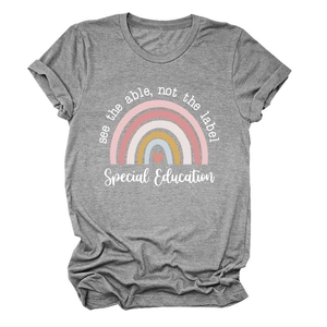 Détail du motif arc-en-ciel et du texte see the able not the label sur le t-shirt gris