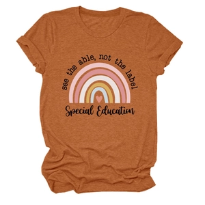 Détail du t-shirt orange rouille avec imprimé arc-en-ciel et slogan inspirant