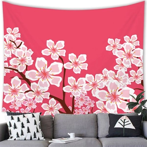 Detail of pink cherry blossom tapestry hanging above a grey sofa in a cozy room