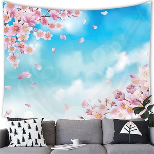 Pink cherry blossom tapestry hung above a gray sofa in a modern living room