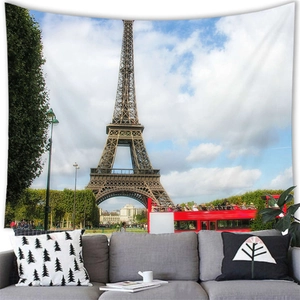 Close-up of printed tapestry with Eiffel Tower and red bus hanging above a grey sofa