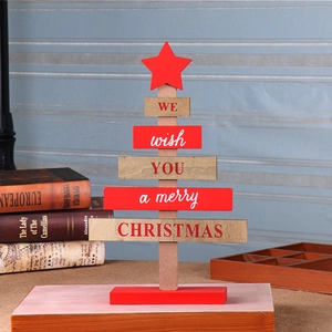 Detail of wooden Christmas tree decor with Merry Christmas text on a desk