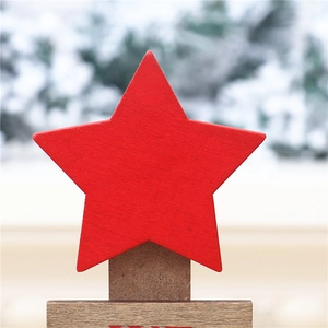 Macro shot of a red wooden star ornament with MERRY text on a rustic timber base