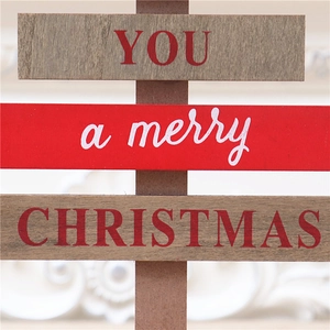 Detail of wooden Christmas sign featuring three layers with red festive text and rustic finish