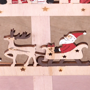 Detail of wooden Christmas ornament showing Santa and reindeer sleigh with laser-cut stars