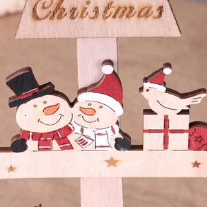 Close-up of laser-cut wooden Christmas ornament featuring a snowman and festive details