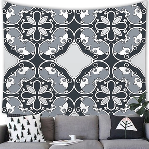 Detail of bohemian geometric mandala tapestry hanging over a modern grey sofa
