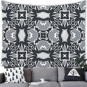 Detail of bohemian geometric tapestry styled with a modern grey sofa and green plant