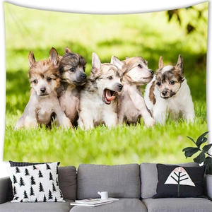 Detailed wall tapestry showing five cute puppies on grass hung above a modern gray sofa