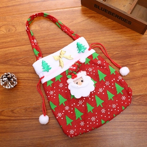 Detail of red Christmas gift bag with Santa Claus 3D figure and white faux fur trim