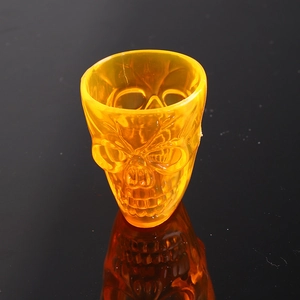 Macro detail of amber skull shot glass showing the textured eye sockets and teeth