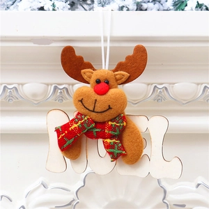 Dettaglio della renna di peluche con targa NOEL appesa su un caminetto bianco