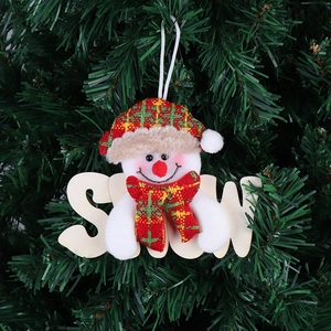 Dettaglio di pupazzo di neve in peluche e decorazione in legno SNOW sull'albero di Natale