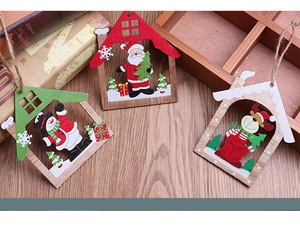 Detailed close-up of three wooden Christmas house pendants with festive painted characters