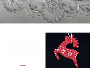 Detail of red wooden reindeer Christmas ornament with white snowflakes and hanging cord