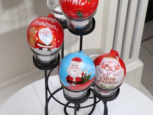 Detailed view of Christmas tin ball ornaments with Santa patterns and red hanging ropes
