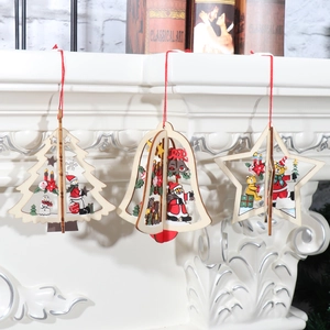 Close-up of 3D wooden Christmas tree bell and star ornaments hanging on a white fireplace