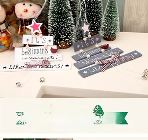 Detail of wooden Christmas tree door hanging with star, bells, and plaid bow decoration