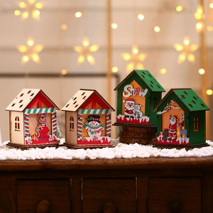 Détail de quatre petites cabanes de Noël en bois lumineuses avec motifs de renne et bonhomme