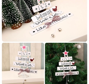 Detail of wooden Christmas tree door hanging with festive bows and silver bell ornament