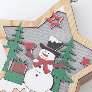 Detail of wooden star Christmas ornament featuring a snowman and painted pine tree