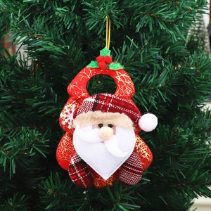 Detail of plush Santa Claus ornament with red texture and gold leaves on a tree
