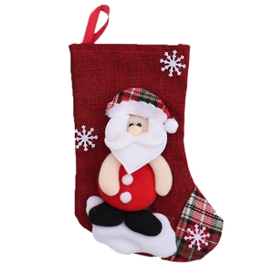 Detail of red burlap Christmas stocking featuring Santa Claus applique and snowflakes