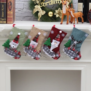 Set of four rustic Christmas stockings featuring Santa and reindeer on a white fireplace