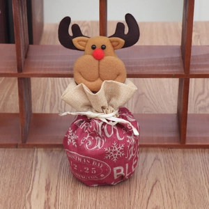 Détail du sac cadeau de Noël en toile de jute avec tête de renne 3D et motifs festifs