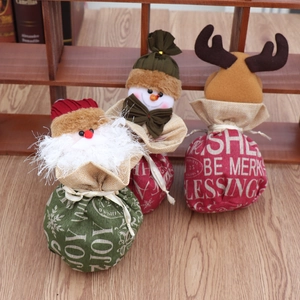 Vue détaillée de trois sacs cadeaux de Noël en toile de jute avec motifs père Noël et renne
