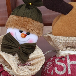 Gros plan du sac cadeau de Noël en toile avec bonhomme de neige en peluche et renne festif