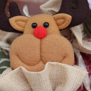 Détail du sac cadeau de Noël avec tête de renne en feutre et texture de toile de jute