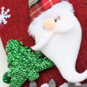 Christmas stocking gift bag with plush Santa Claus and sequin tree on red burlap fabric