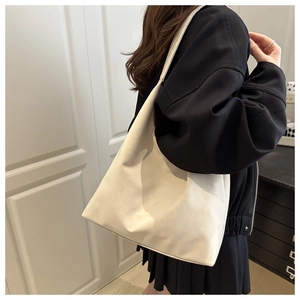 Minimalist white hobo shoulder bag with a slouchy design and smooth matte leather texture