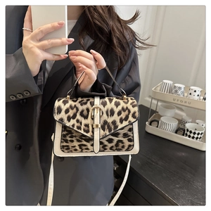 Detail of leopard print crossbody bag with gold buckle and adjustable strap